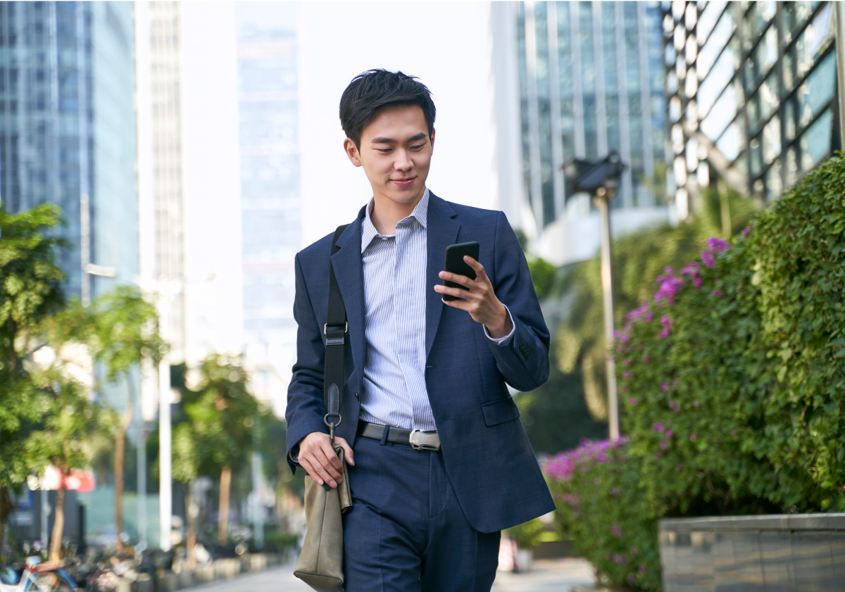 Smiling man using cell phone on street