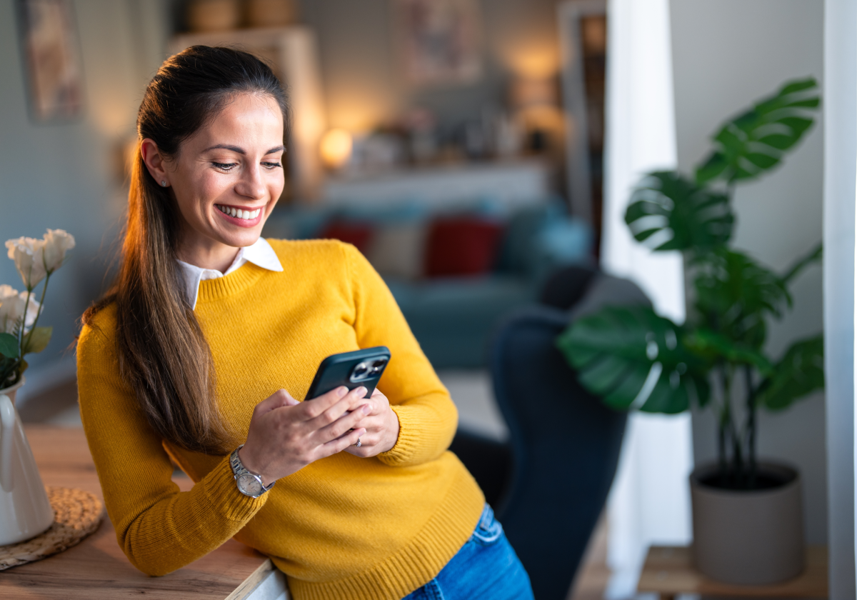 Woman smiling while using mobile phone in Slovenia