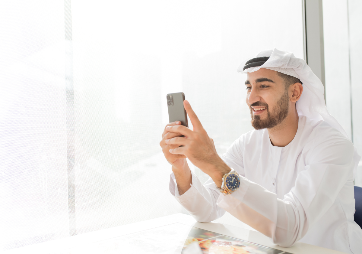 Man wearing traditional clothing using mobile phone in Kuwait
