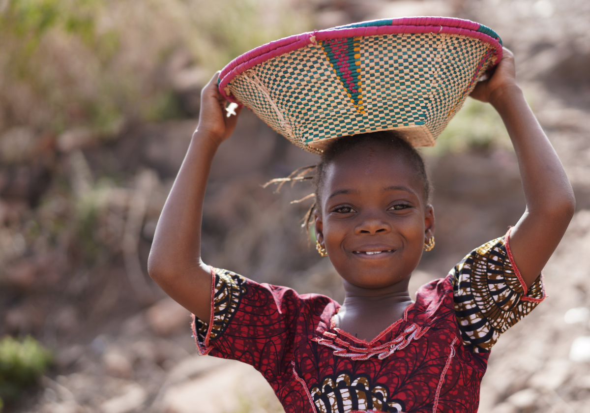 Photo of a small girl holding a basket in Togo