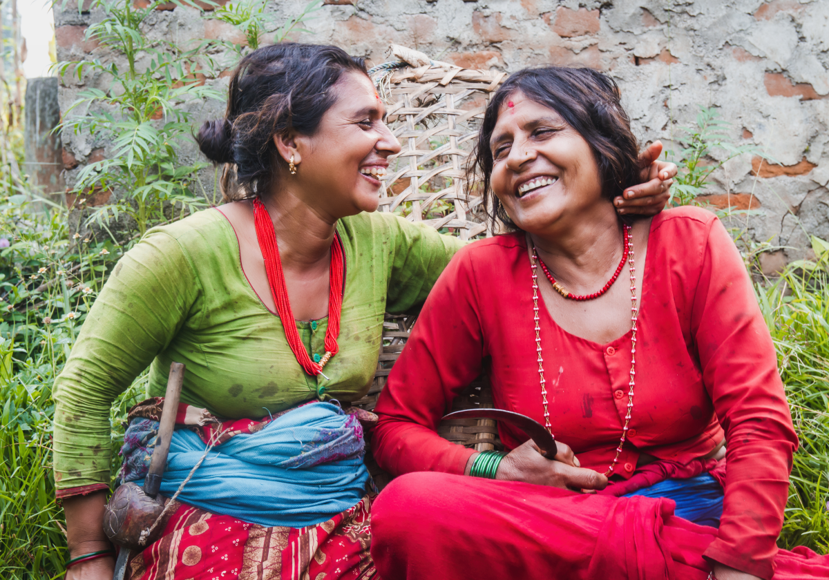 Two woman wearing traditional clothing embracing in Nepal